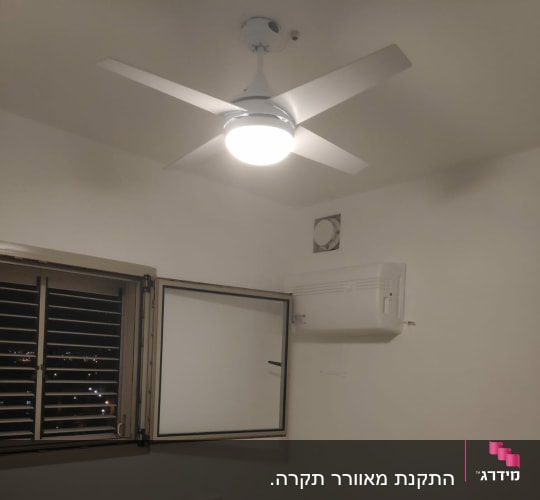 מאוורר תקרה מואר בחדר עם מזגן על הקיר